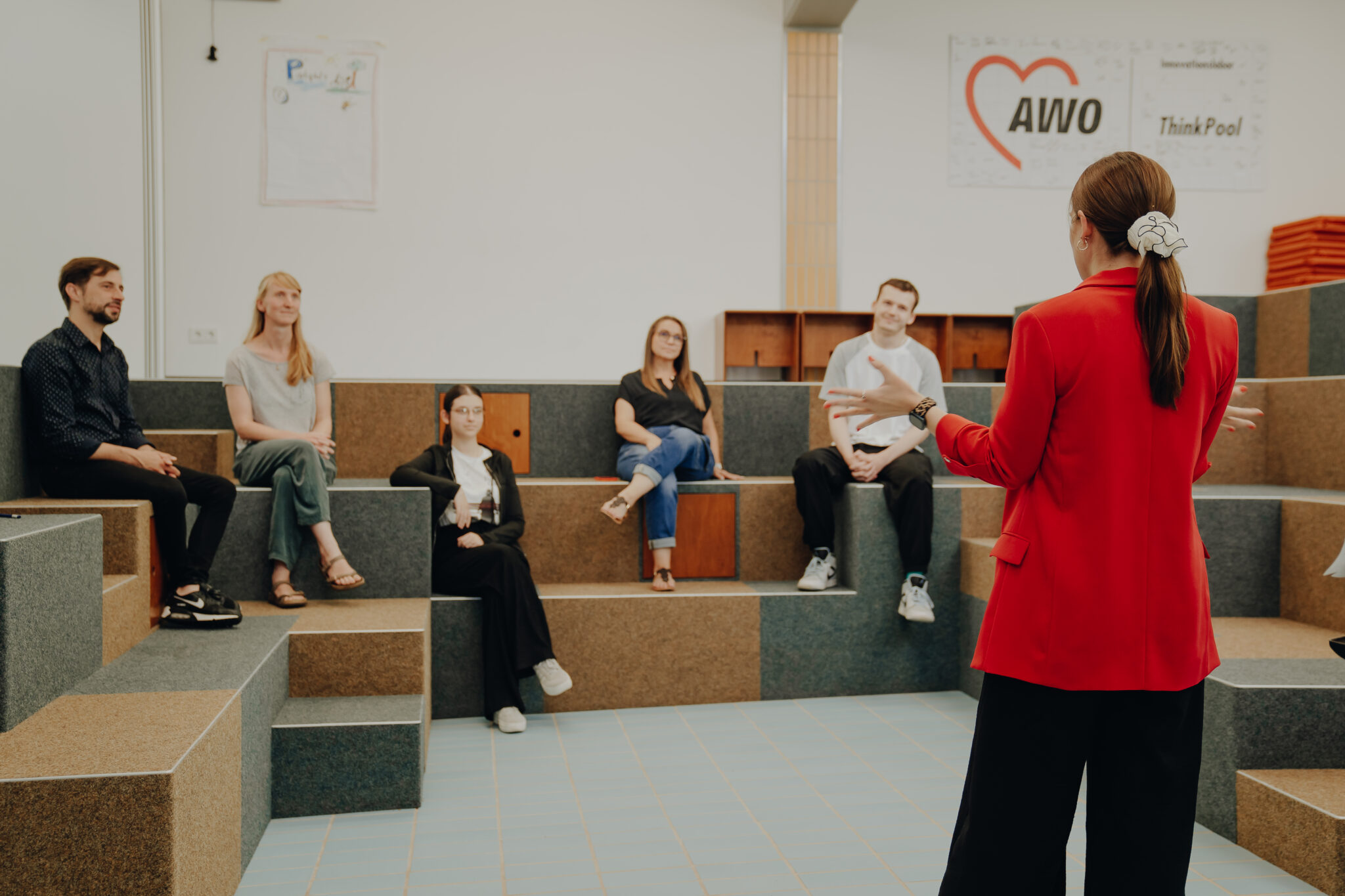 Mehrere Personen nehmen an einer Veranstaltung in einem Saal teil.