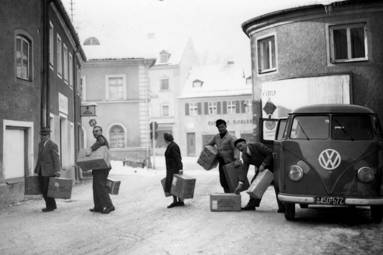 Historische Aufnahme von Menschen beim Transport von Hilfsgütern in einer Stadt.